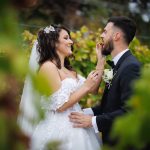Bride feeding groom grapes in a vineyard