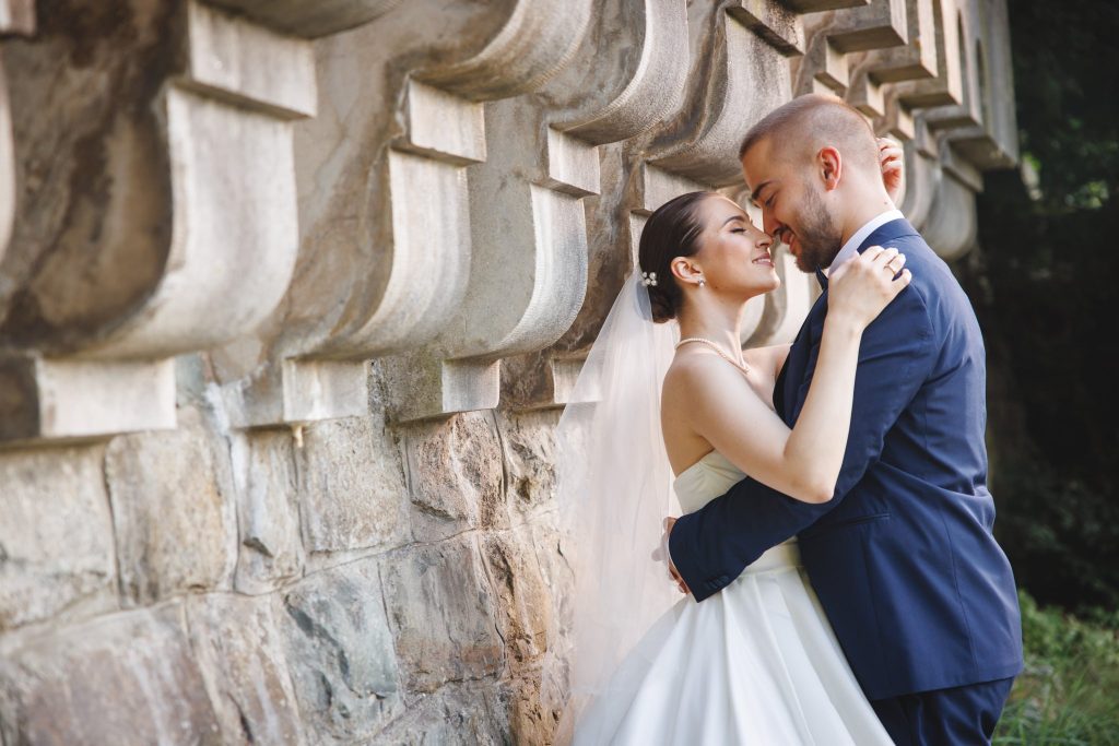 Bride and groom laughing and hugging under a terrace