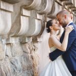 Bride and groom laughing and hugging under a terrace