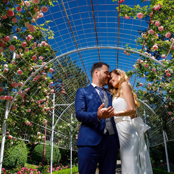 Bride and groom embracing in a lush, elegant garden