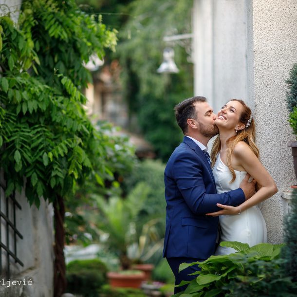 Groom lovingly kissing and hugging the bride