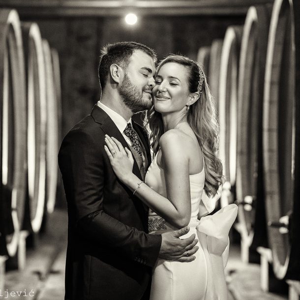 Bride and groom embracing warmly inside a winery