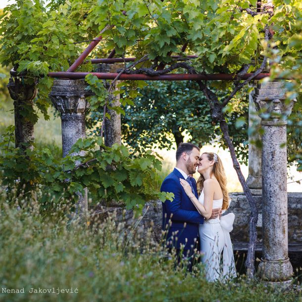 Bride and groom embracing, about to kiss in a garden