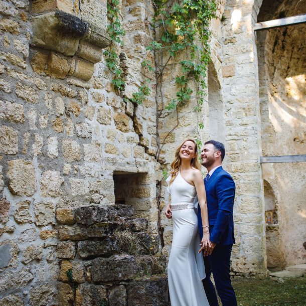 Bride and groom posing side by side, holding hands
